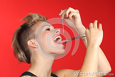 Woman piercing the tongue herself Stock Photo