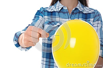 Woman piercing yellow balloon Stock Photo