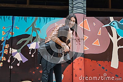 Woman piggy riding on her friend`s back Stock Photo