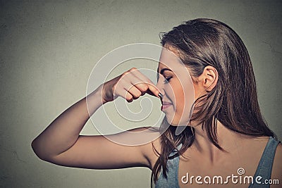 Woman pinches nose with fingers looks with disgust away something stinks Stock Photo