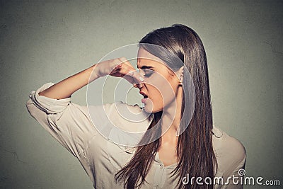 Woman pinches nose looks with disgust something stinks bad smell Stock Photo