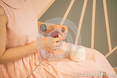 Woman in pink dress knitting. hobby crafts things. Horizontal composition Stock Photo