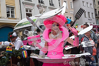 Woman in pink fancy costume with cutlery in the back Editorial Stock Photo