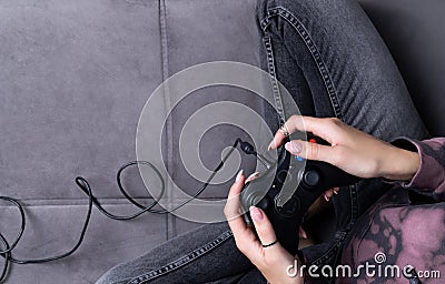 Woman in pink hoodie with manicured hands hold gamepad Stock Photo