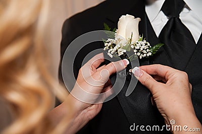 A Woman Pinning A Boutonniere Stock Photo