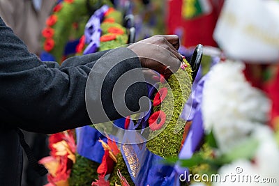 Woman Places Remembrance Day Poppy on Wreath Editorial Stock Photo