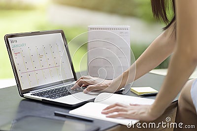 Woman planning agenda and schedule using calendar event planner. Stock Photo