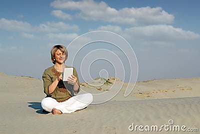 Woman play with tablet pc in desert Stock Photo