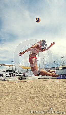 Woman player beach volleyball jumping to hit the ball. Spike Editorial Stock Photo