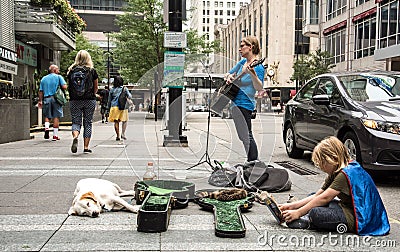 Woman playing guitar for tips. Editorial Stock Photo