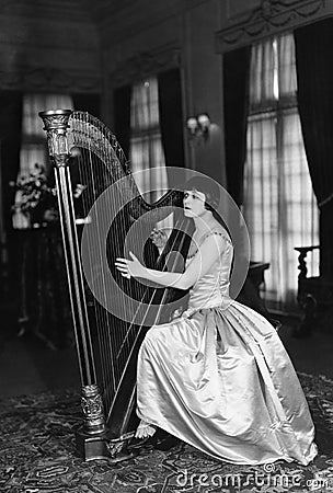 Woman playing harp Stock Photo