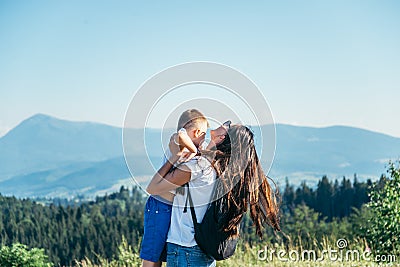 Woman playing with her kid on the peak of the mountain Stock Photo