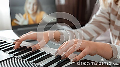 Woman playing piano during video call via laptop. Female hands musician pianist improves skills playing piano online Stock Photo