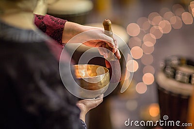 Woman playing on a tibetian singing bowl Stock Photo