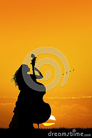 Woman plays the double bass at sunset Stock Photo