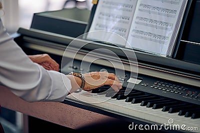 Woman plays electric piano at outdoor music performance, close up view to nimble hands Stock Photo