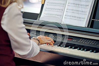 Woman plays electric piano at outdoor music performance, close up view to nimble hands Stock Photo