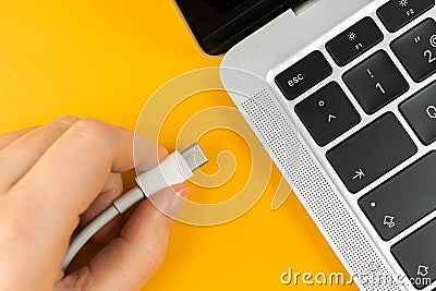 Woman plugging charger in a laptop. Type C charging port. Low battery concept photo Stock Photo