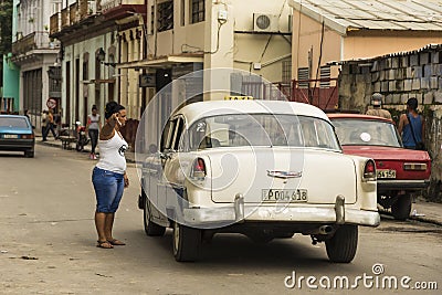 Woman pointing direction to vintage Chevy taxi Havana Editorial Stock Photo