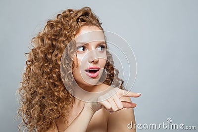 woman pointing finger. Beautiful female model with natural make-up, frizzy long hair and friendly smile Stock Photo