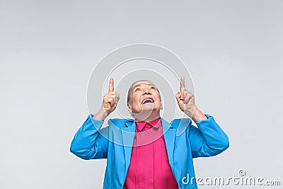 Woman pointing finger up at copy space and toothy smiling Stock Photo