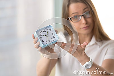 Woman pointing at time, focus on clock, deadline punctuality con Stock Photo