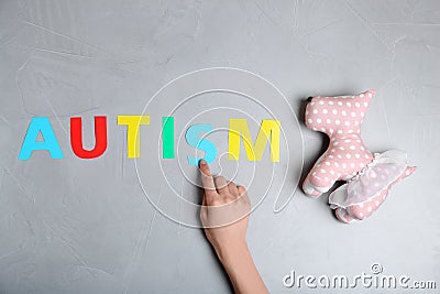 Woman pointing at word AUTISM and toy dog Stock Photo