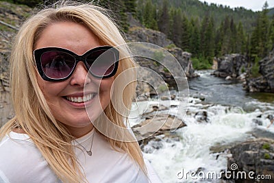 Woman poses by Dagger Falls waterfall in Idaho in the Salmon-Challis National Forest Stock Photo