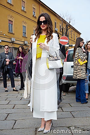Woman poses for photographers with white coat, yellow shirt and coccinelle bag before Gucci fashion show, Editorial Stock Photo