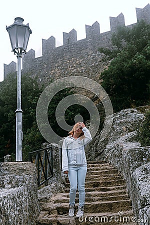 Woman Posing against the backdrop of the fortress, steps, stairs. Mystical atmosphere, fog and mist. Vertical photo. Pass of the Stock Photo