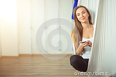 Woman posing in anti-gravity aerial yoga hammock. relax with phone Stock Photo