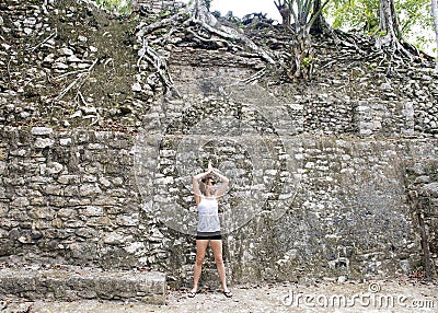 Woman posing in front of a Ruin in the COBA Zona Arqueologica Stock Photo