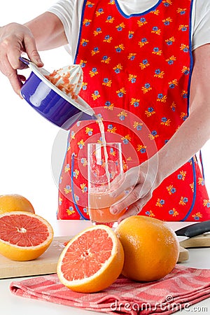 Woman pouring fresh grapefruit juice Stock Photo