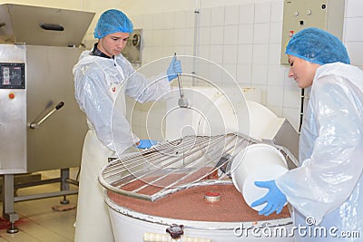 Woman pouring ingredient into vat Stock Photo