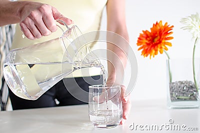 Woman pouring water into a glass Stock Photo