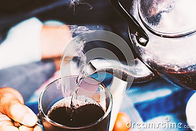 Woman pours boiling water into the cup of coffee Stock Photo