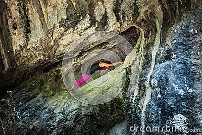 Woman practice yoga in small cave on trip to mountain Stock Photo