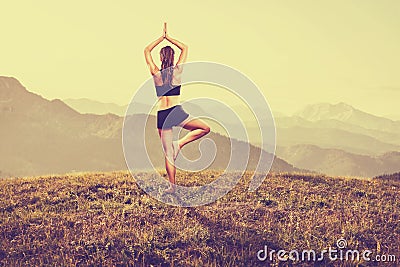 Woman practices yoga in the mountains Stock Photo