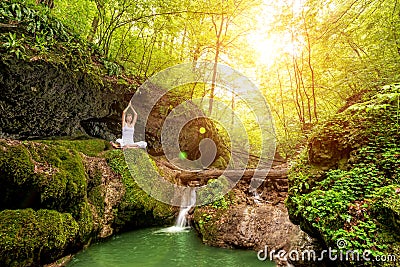 Woman practices yoga at the waterfall. Sukhasana pose Stock Photo