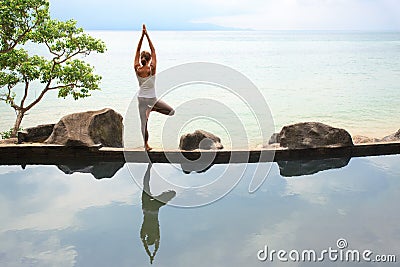 Woman practicing morning meditation Yoga at the beach Stock Photo