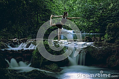 Woman practicing yoga at cascade Stock Photo