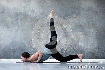 Woman practicing yoga doing eka pada Shalabhasana, the Locust pose variation Stock Photo