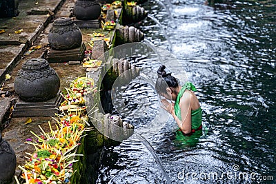 Woman pray and bath holy spring waters in Tirta Empul water temple, Bali, Indonesia. Stock Photo