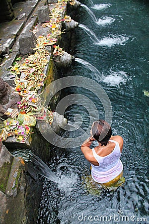 Woman in prayer in holy water at Pura Tirta Empul Stock Photo