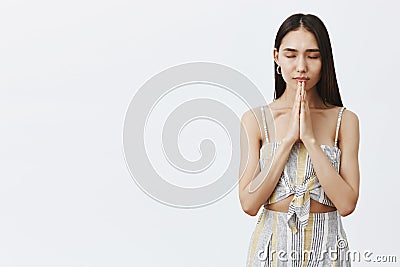 Woman praying before dinner, thanking for food. Portrait of relaxed and calm good-looking hopeful female, closing eyes Stock Photo