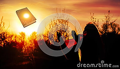 Woman praying pious with sunrise Stock Photo