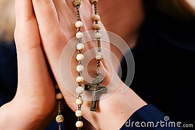 Woman praying with rosary to God Stock Photo