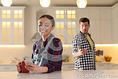 Woman preferring smartphone over spending time with her boyfriend. Jealousy in relationship Stock Photo