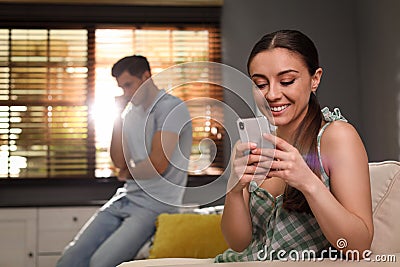 Woman preferring smartphone over spending time with her boyfriend. Jealousy in relationship Stock Photo