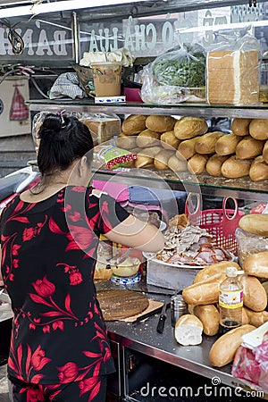 Woman prepares a sandwich in a street of Ho Chi Minh City, Vietnam Editorial Stock Photo